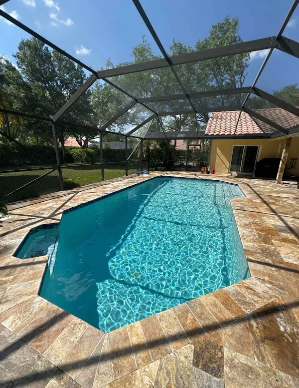 Clear blue swimming pool inside a screened patio